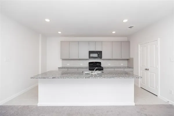 a view of kitchen with stainless steel appliances granite countertop refrigerator sink and stove