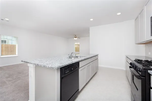 a kitchen with granite countertop a sink and a stove
