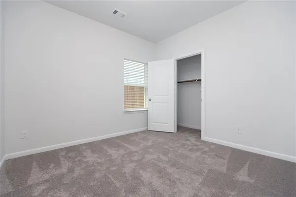 a view of an empty room with closet and window