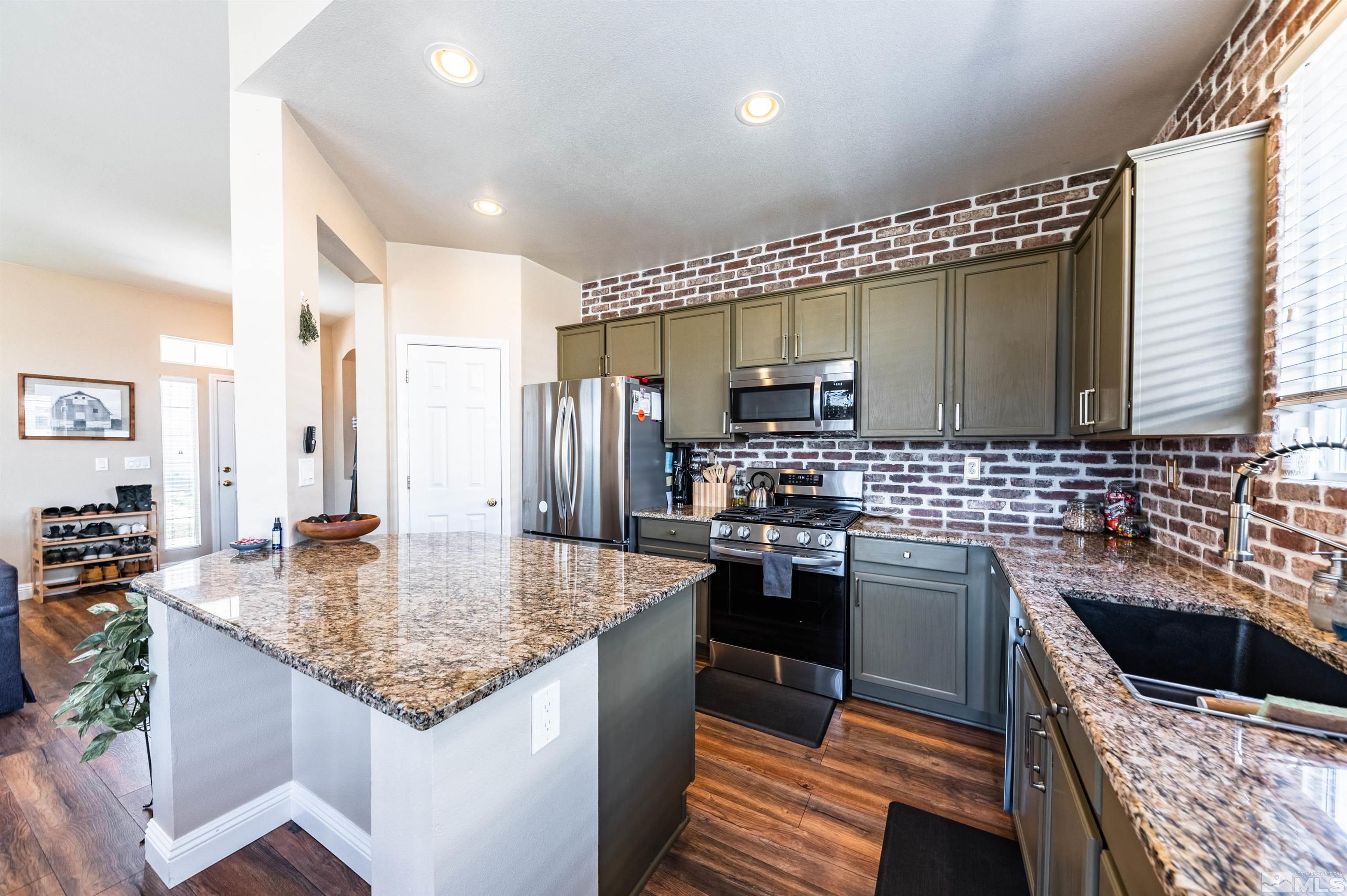 10472 Summershade Lane Reno, NV 89521 - Photo 17 of 30 a kitchen with stainless steel appliances granite countertop a sink stove and refrigerator