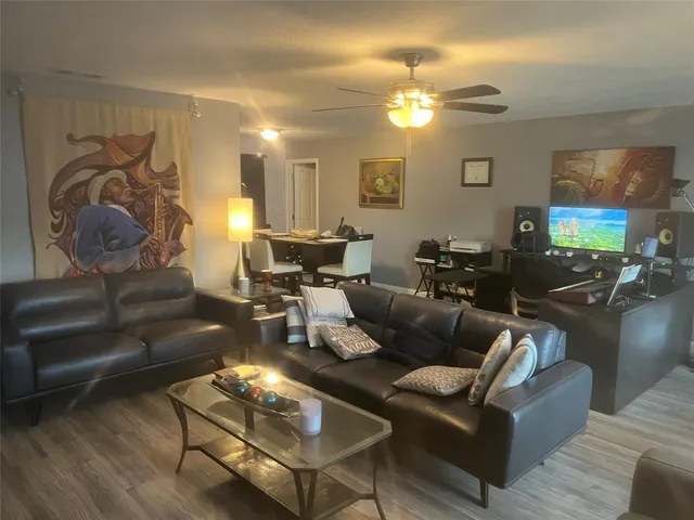 a living room with furniture a chandelier and a flat screen tv