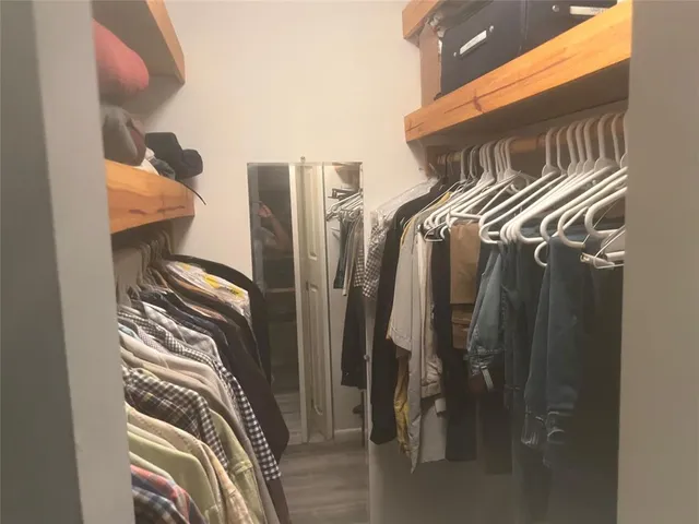 a view of walk in closet with clothes and shoes