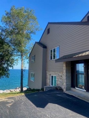 141 South Lakeshore Drive, Unit B1 Racine, WI 53403 - Photo 18 of 26 a front view of a house with a yard