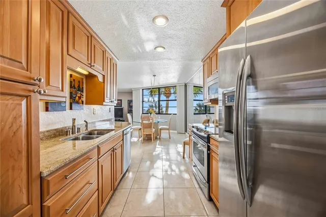 a kitchen with granite countertop a refrigerator and a sink