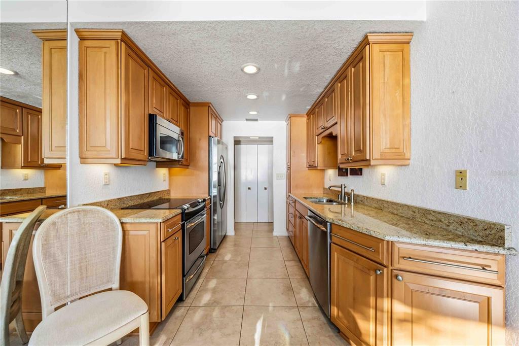 1050 Longboat Club Road, Unit 301 Longboat Key, FL 34228 - Photo 21 of 57 a kitchen with stainless steel appliances granite countertop a stove a sink and a microwave