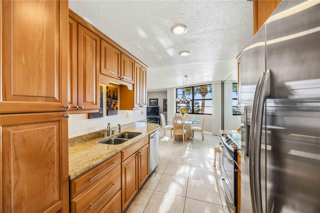 1050 Longboat Club Road, Unit 301 Longboat Key, FL 34228 - Photo 22 of 57 a kitchen with granite countertop a refrigerator and a sink