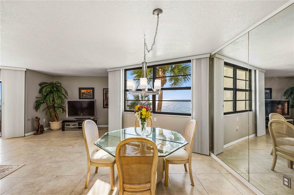 1050 Longboat Club Road, Unit 301 Longboat Key, FL 34228 - Photo 9 of 57 a dining room with furniture window wooden floor and a chandelier