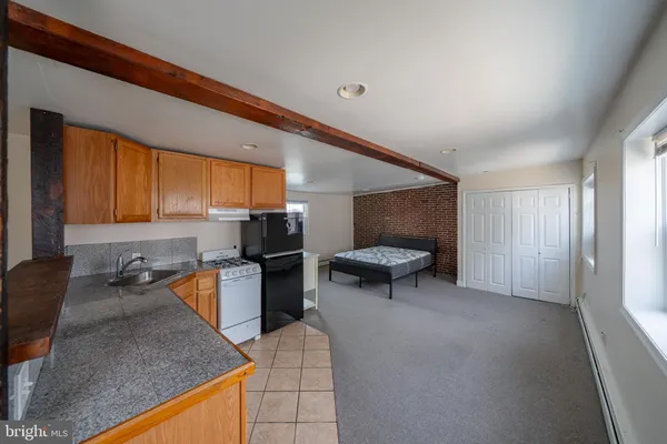 a kitchen with a sink dishwasher a stove and a refrigerator with wooden floor