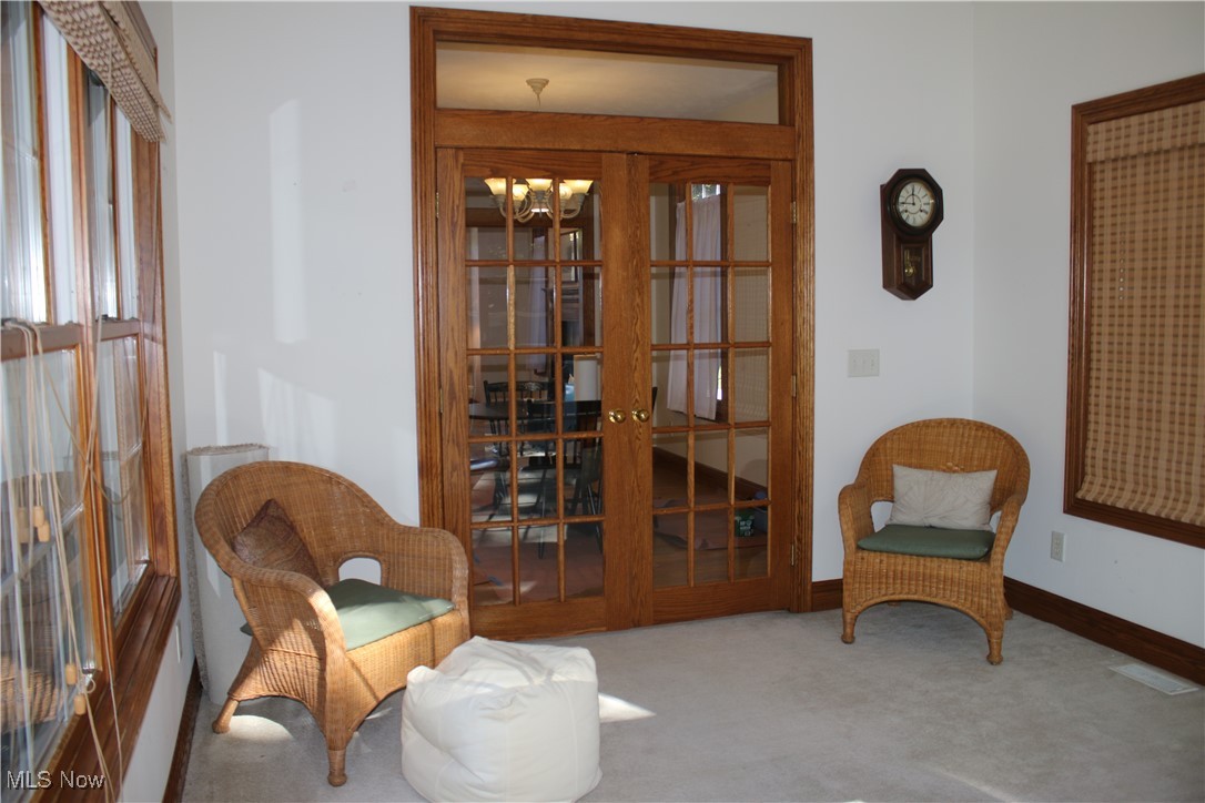 1837 Haines Road Madison, OH 44057 - Photo 11 of 29 Living area featuring carpet, a chandelier, and french doors