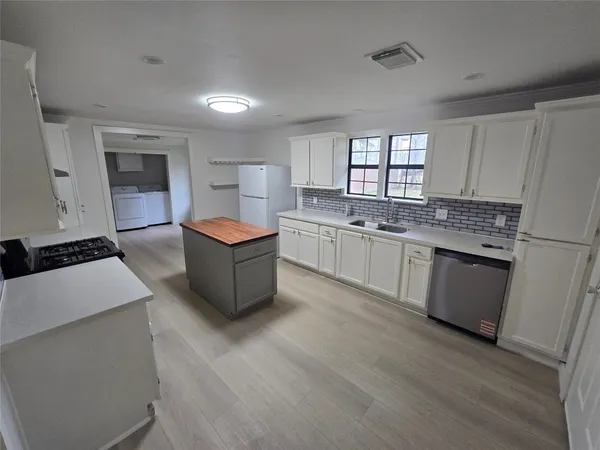 a large kitchen with stainless steel appliances granite countertop a stove a sink dishwasher and a refrigerator