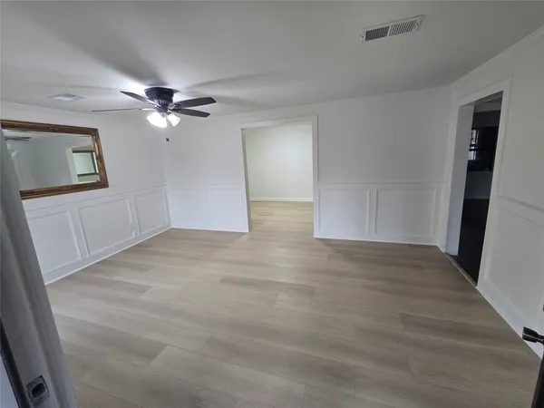 a view of empty room with wooden floor