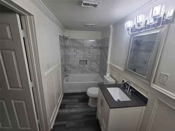 a bathroom with a sink a toilet a mirror and shower