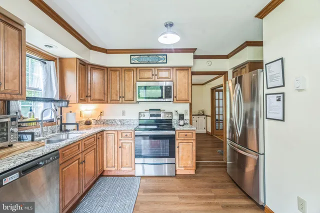 a large kitchen with stainless steel appliances granite countertop a refrigerator stove and sink