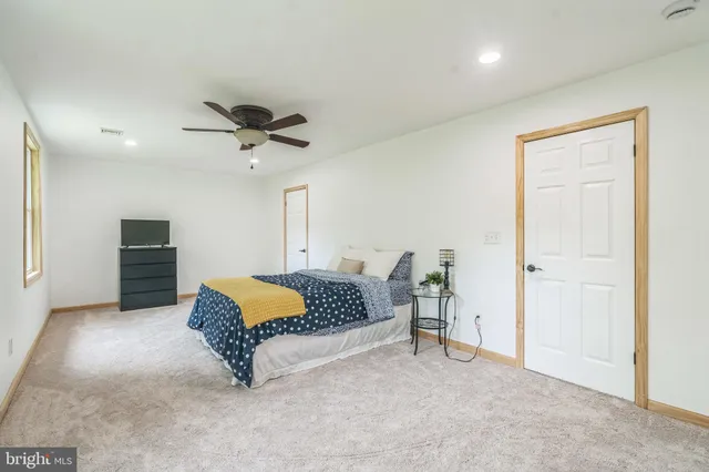 a living room with furniture and a ceiling fan