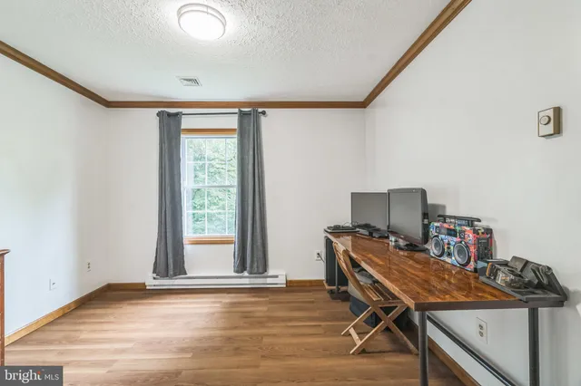a view of a workspace with furniture and a window
