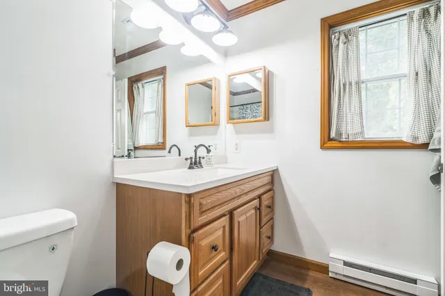 a bathroom with a sink mirror vanity and toilet