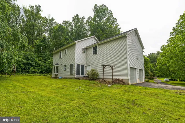 a view of a house with a yard and trees