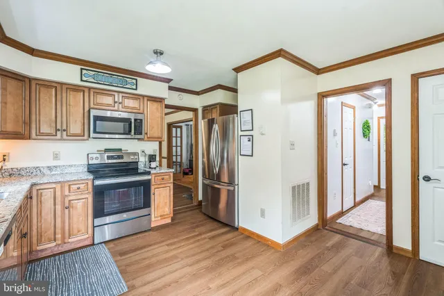a kitchen with stainless steel appliances granite countertop a refrigerator and a stove top oven