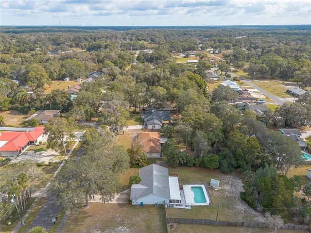 a view of swimming pool with large trees and a big yard