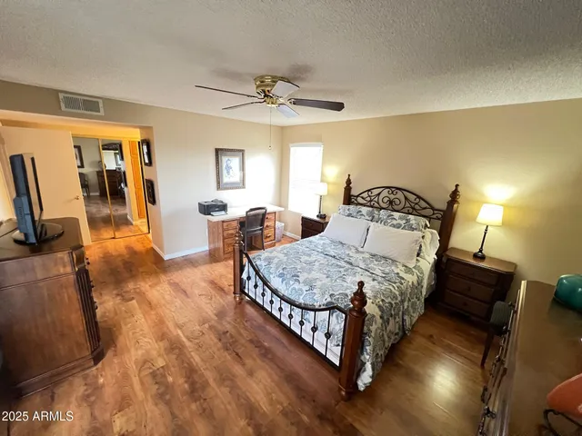 a bedroom with a bed and wooden floor