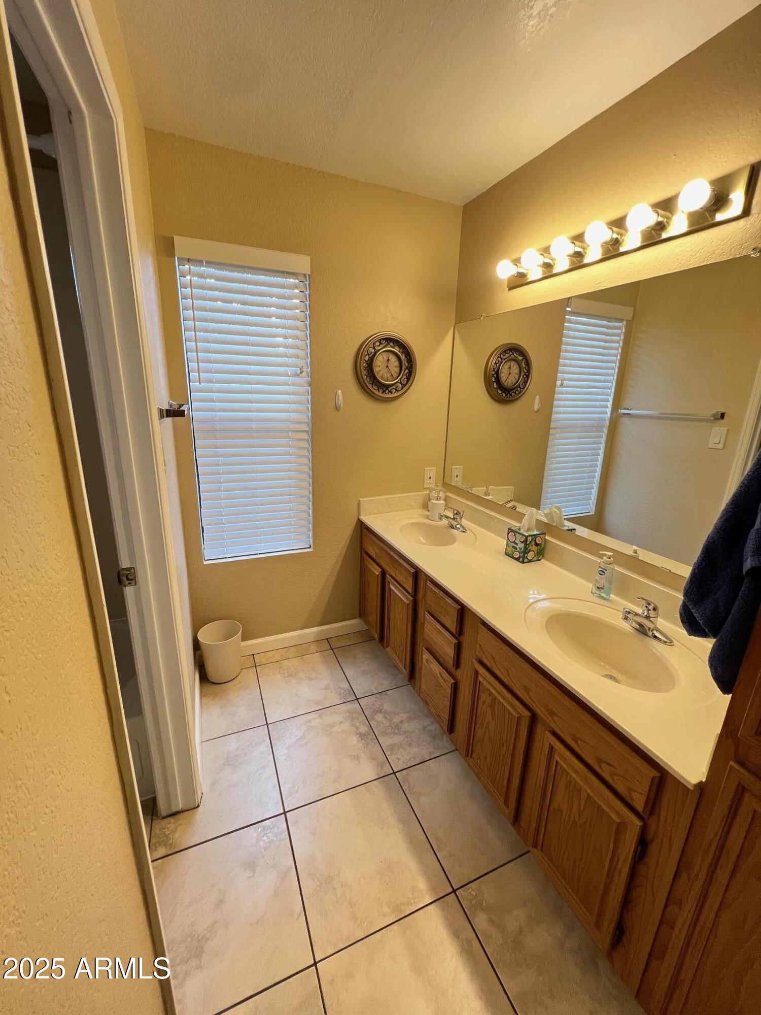 5518 East Lindstrom Lane, Unit 2020 Mesa, AZ 85215 - Photo 18 of 35 a bathroom with a sink a mirror and a shower