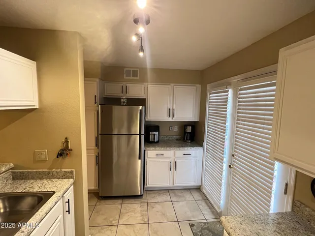 a kitchen with a sink a refrigerator and cabinets