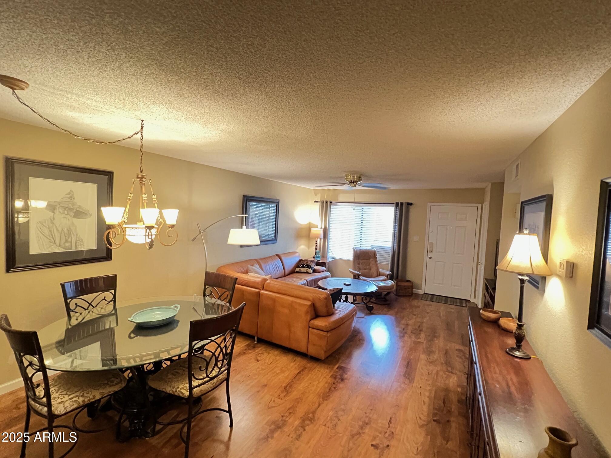 5518 East Lindstrom Lane, Unit 2020 Mesa, AZ 85215 - Photo 25 of 35 a living room with furniture and a chandelier