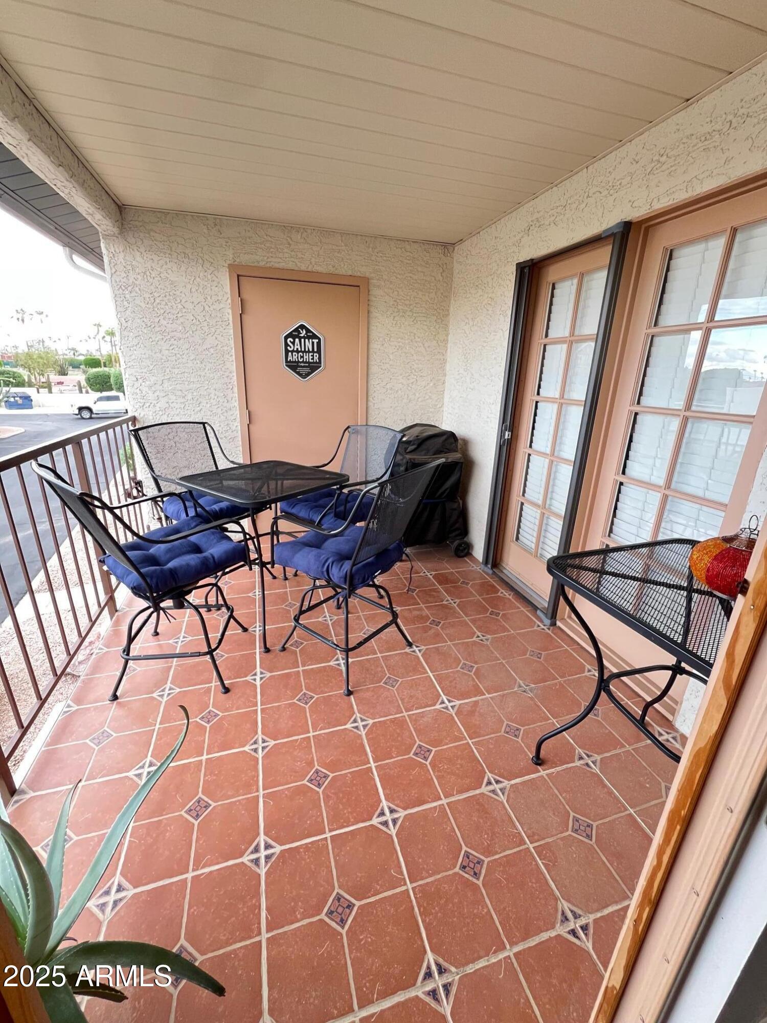 5518 East Lindstrom Lane, Unit 2020 Mesa, AZ 85215 - Photo 35 of 35 a living room with a black white checkered floor with a coffee table and chair with a large window