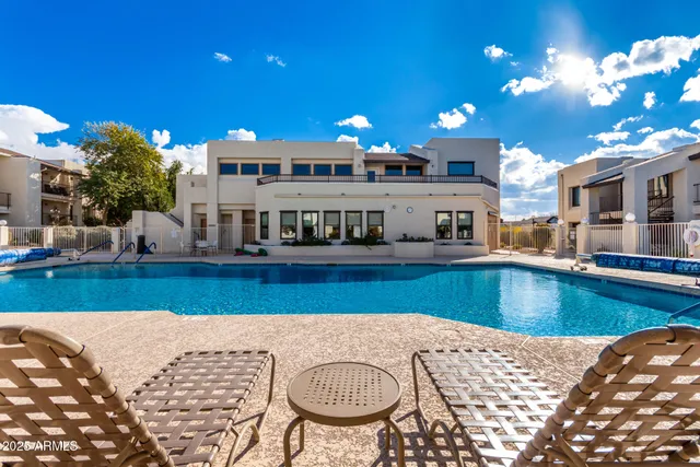 a view of a swimming pool with a patio and a fountain