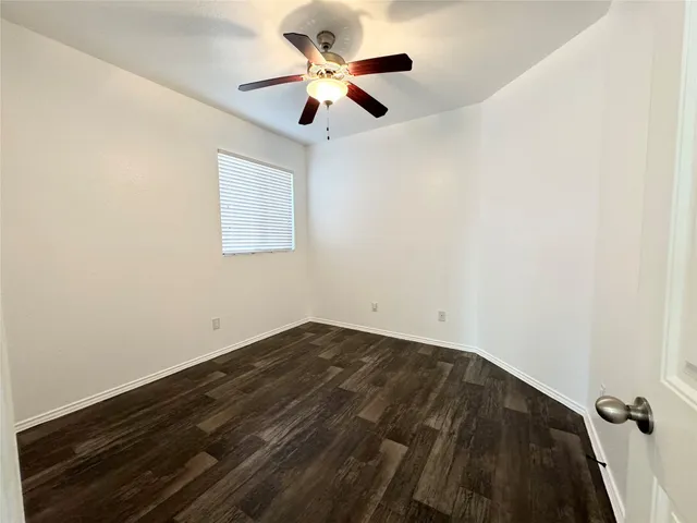 an empty room with a window and a ceiling fan