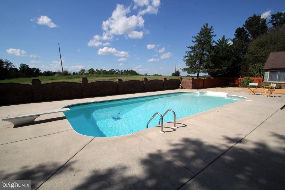 13008 Still Meadow Road Smithsburg, MD 21783 - Photo 17 of 60 a view of a swimming pool with an outdoor seating and a bathroom