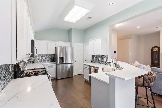 a large white kitchen with sink stove and refrigerator