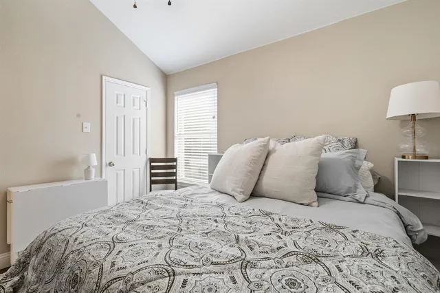 a bedroom with a large bed and a lamp