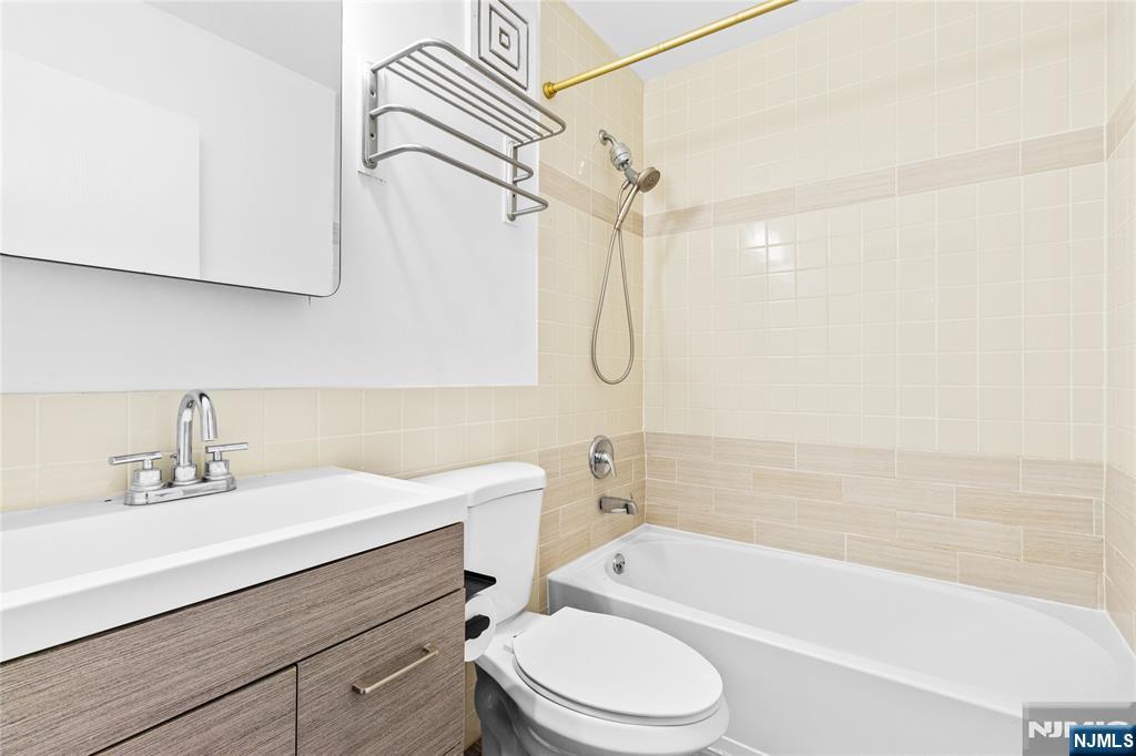 10 Orchard Street, Unit 3E Hackensack, NJ 07601 - Photo 16 of 23 a bathroom with a sink a mirror toilet and bathtub