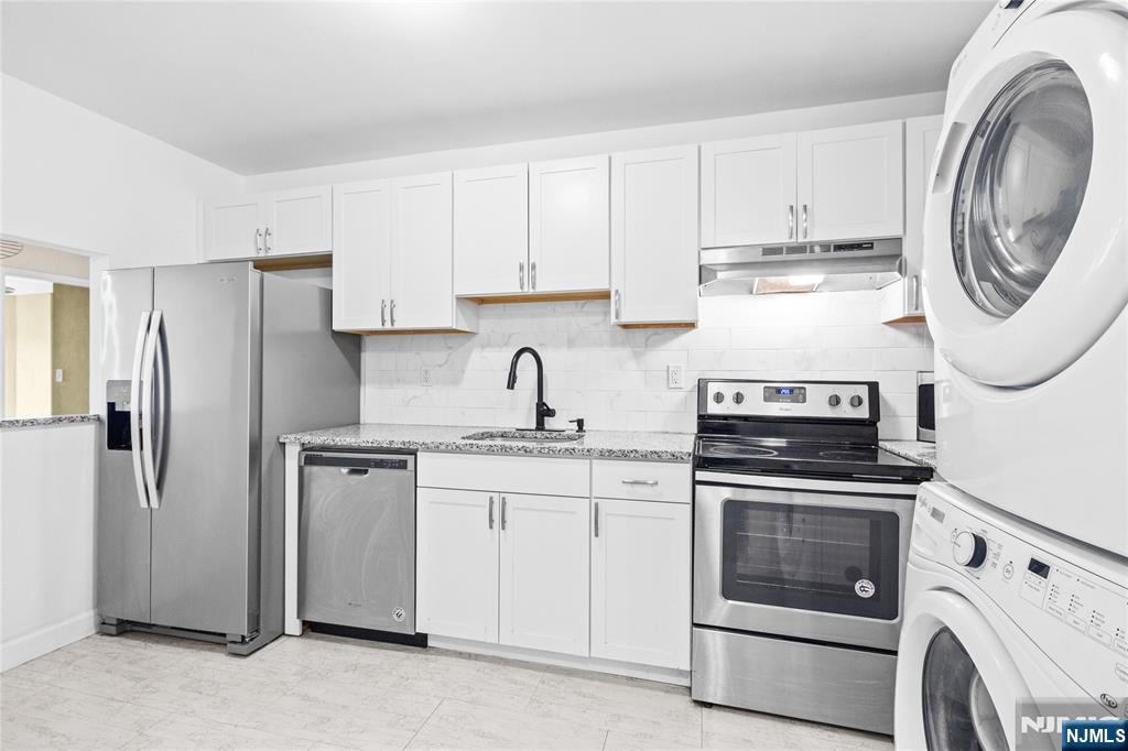 10 Orchard Street, Unit 3E Hackensack, NJ 07601 - Photo 6 of 23 a kitchen with white cabinets and stainless steel appliances