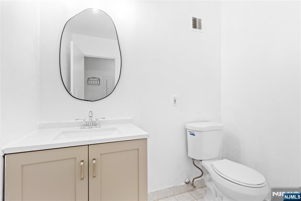10 Orchard Street, Unit 3E Hackensack, NJ 07601 - Photo 8 of 23 a bathroom with a toilet a sink and mirror