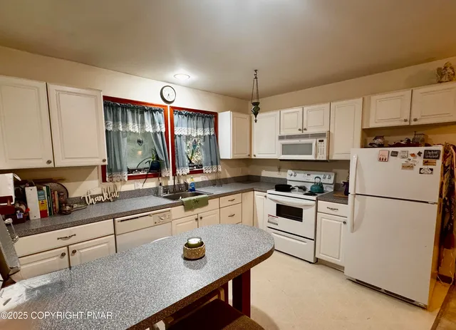 a kitchen with stainless steel appliances granite countertop a sink a stove a refrigerator and island with wooden floor