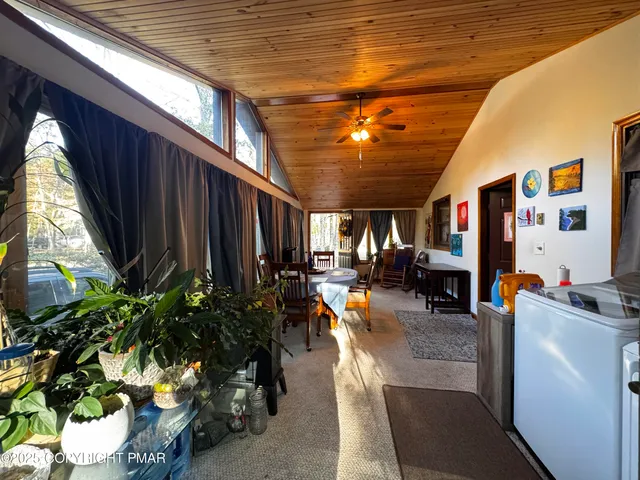 a living room with patio furniture and a potted plant