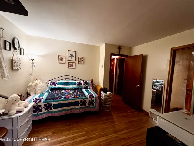 a bedroom with a bed and a flat tv screen on the dresser