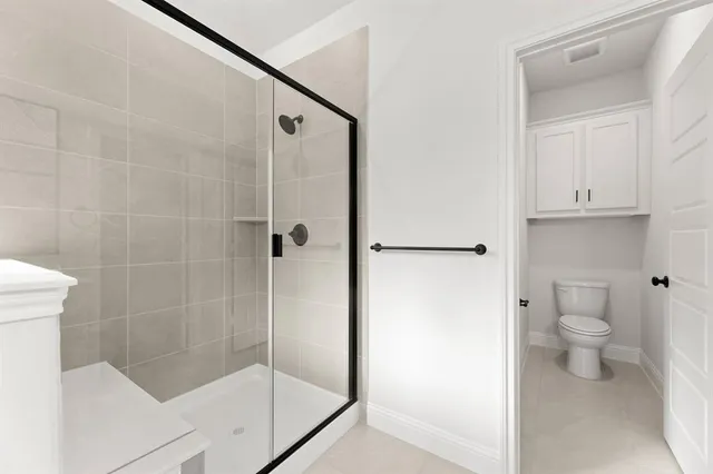 a bathroom with a shower a toilet and sink