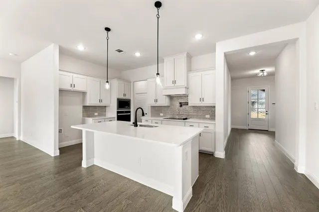 a large kitchen with white cabinets and stainless steel appliances