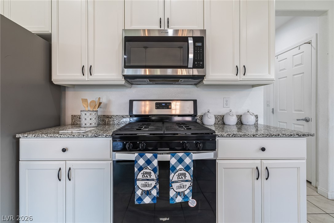 5510 Ripple Ridge Avenue Las Vegas, NV 89139 - Photo 24 of 45 This modern kitchen features crisp white cabinetry, durable granite countertops, and stainless steel appliances.