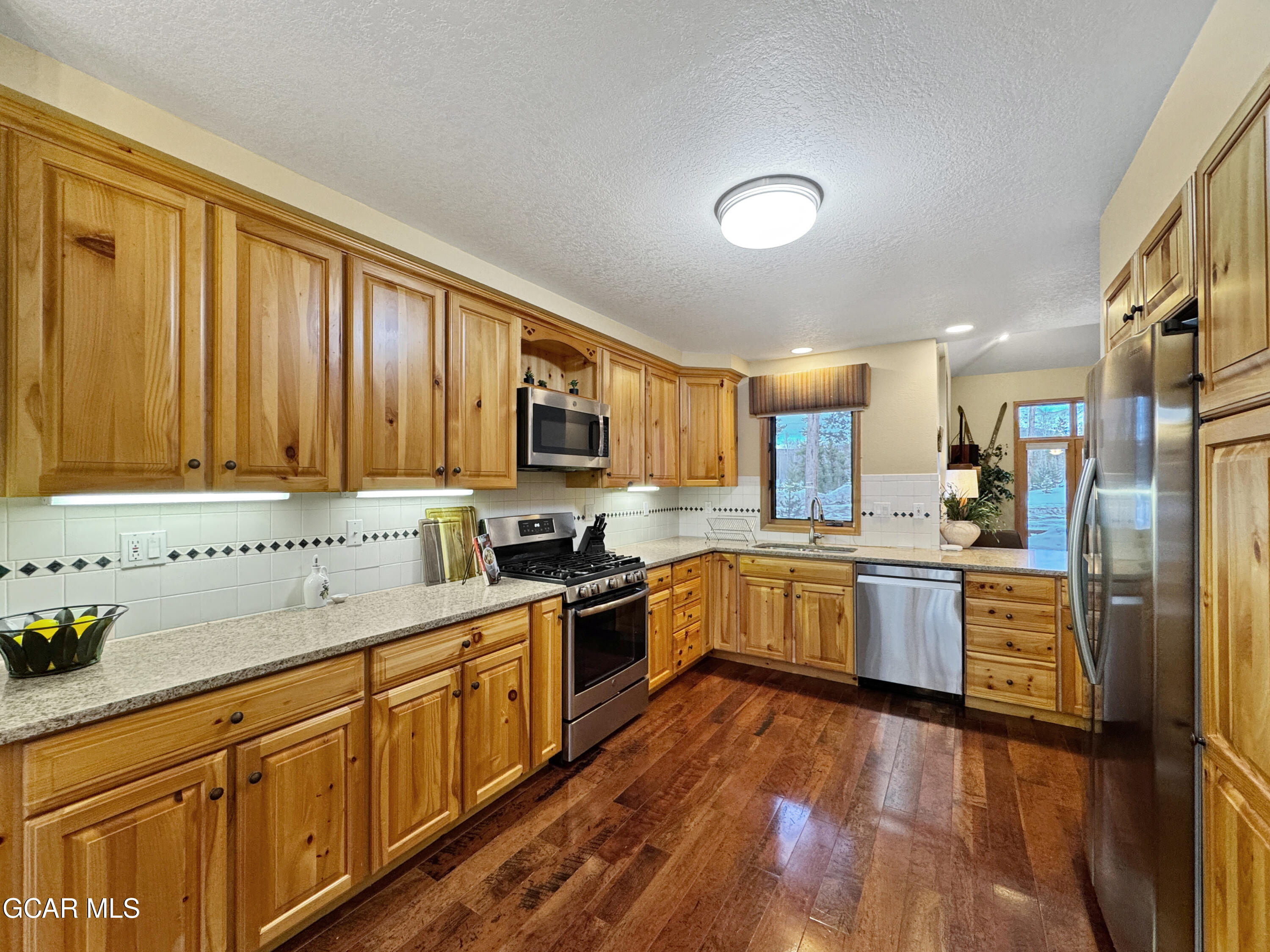 1232 Gcr 8 Tabernash, CO 80478 - Photo 14 of 51 a kitchen with cabinets wooden floor and stainless steel appliances