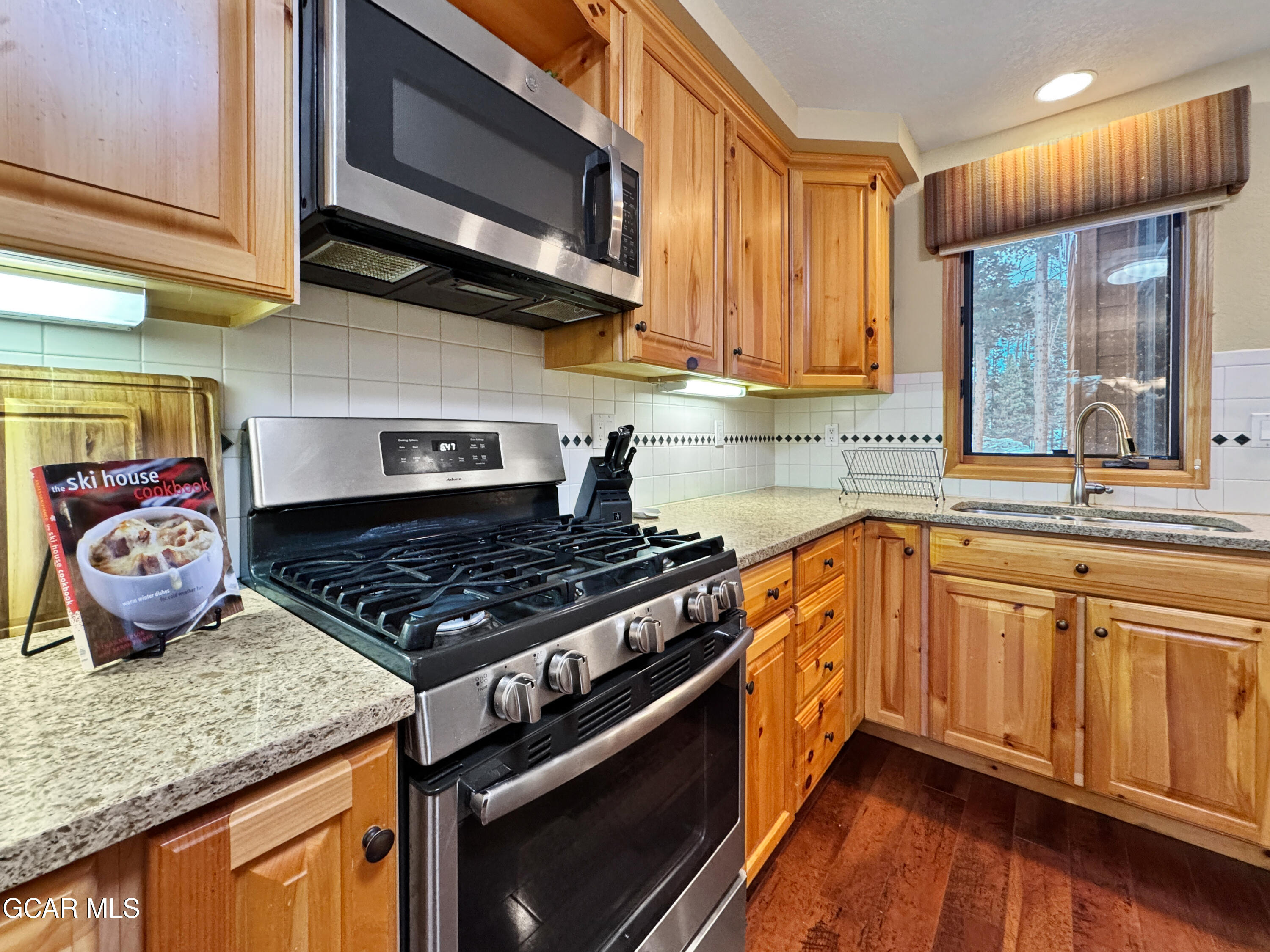 1232 Gcr 8 Tabernash, CO 80478 - Photo 16 of 51 a kitchen with stainless steel appliances granite countertop a stove a sink and a microwave