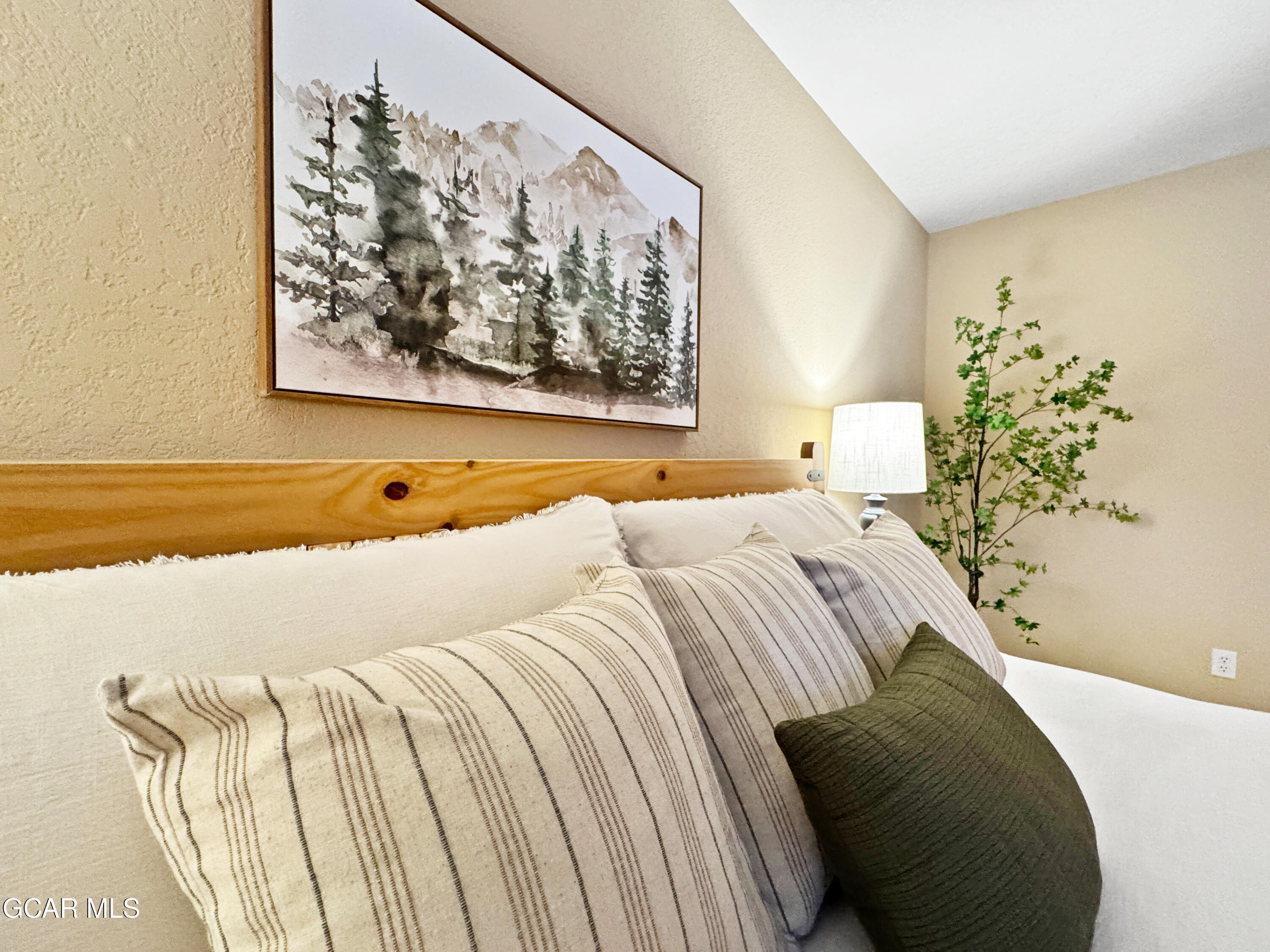 1232 Gcr 8 Tabernash, CO 80478 - Photo 22 of 51 a bed sitting in a bedroom next to a wall painting on the wall and a potted plant