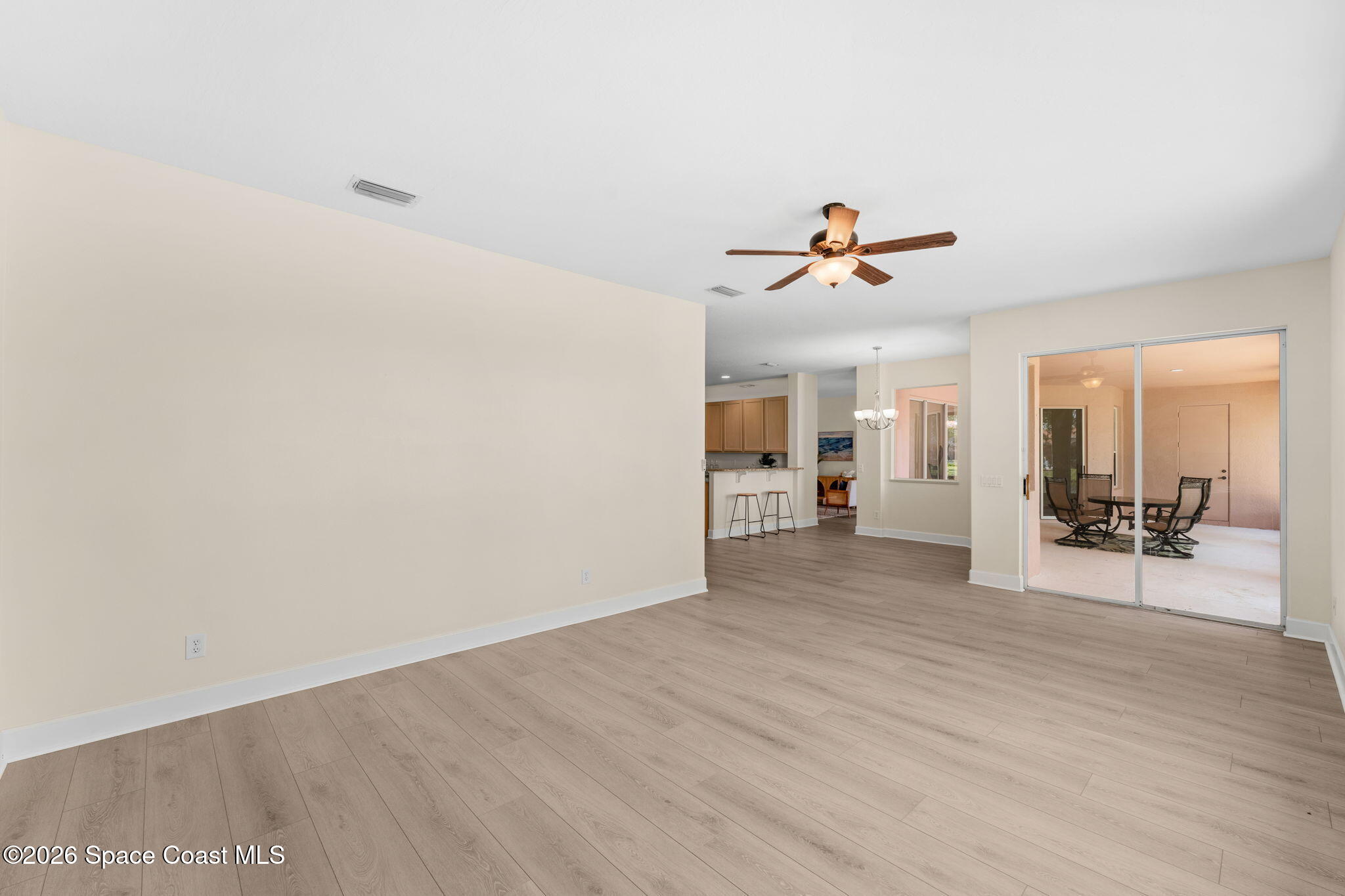 541 Oceanside Boulevard Indialantic, FL 32903 - Photo 18 of 51 a view of a livingroom with wooden floor and a ceiling fan