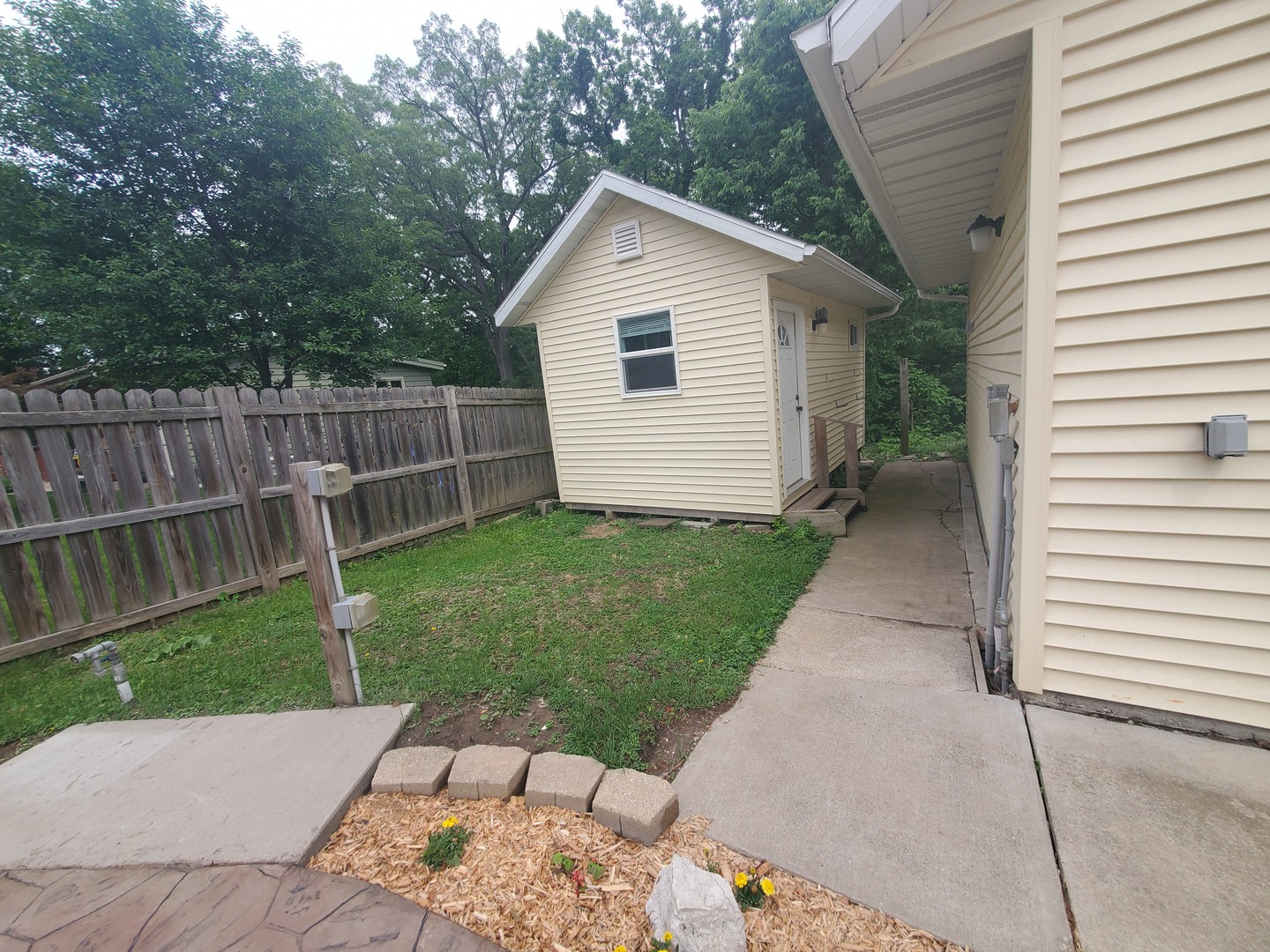 712 3rd Street Moline, IL 61265 - Photo 11 of 29 a backyard of a house with plants and wooden fence