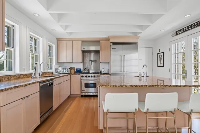a large kitchen with granite countertop a sink and cabinets