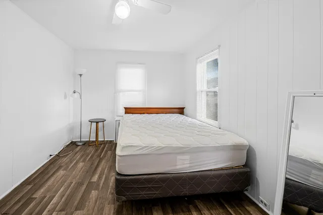 a spacious bedroom with a bed and ceiling fan