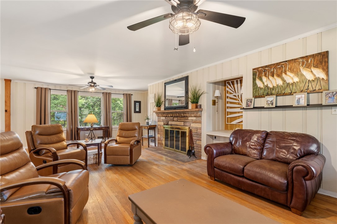 1105 Greenacres Anderson, SC 29621 - Photo 5 of 46 A comforting living room offers a stone-faced fireplace and lustrous hardwood flooring.